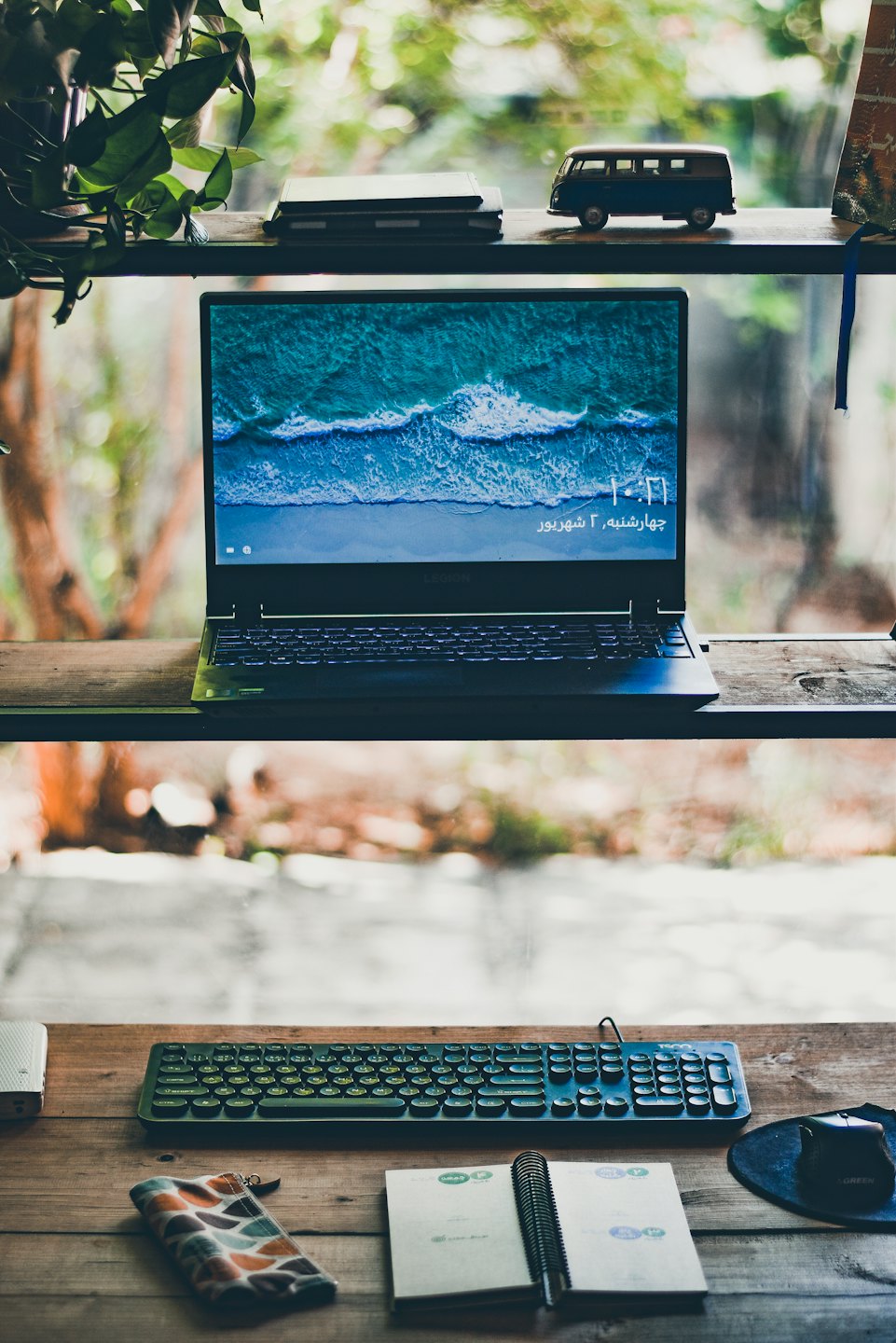 A laptop and stationery arranged on a wooden desk.