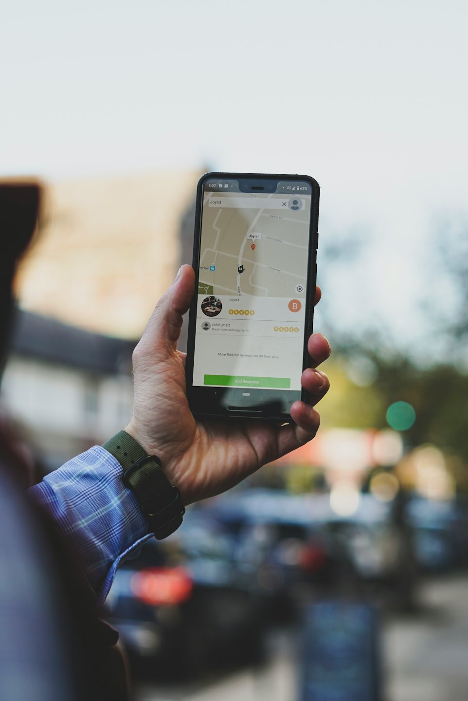 Person uses a smartphone app showing a map and business details.